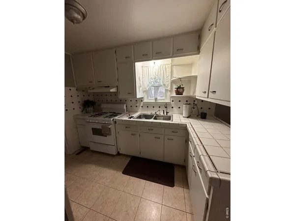 a kitchen with stainless steel appliances granite countertop a refrigerator and a stove