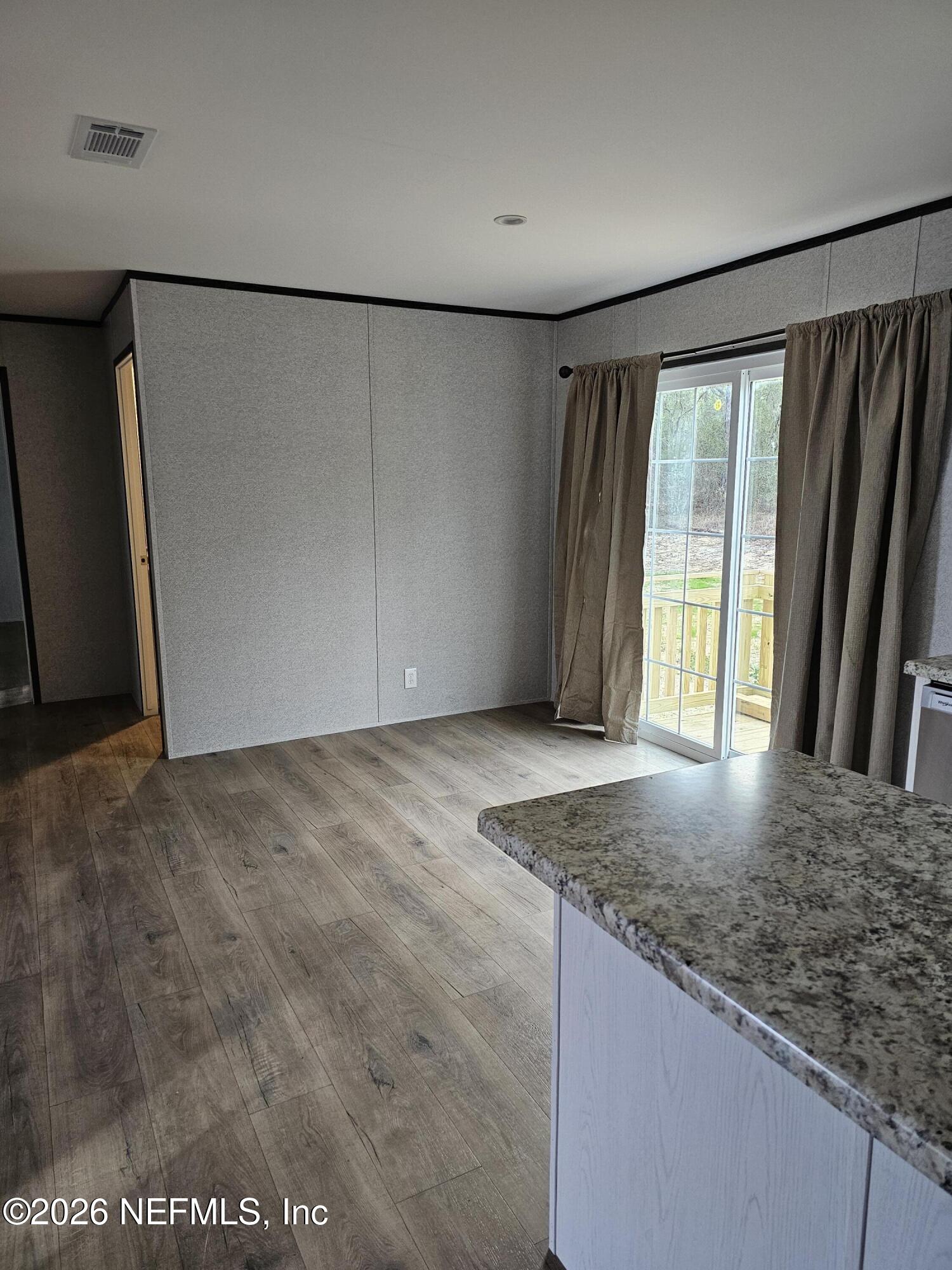 295 Baden Powell Road Hawthorne, FL 32640 - Photo 15 of 15 an empty room with wooden floor and windows