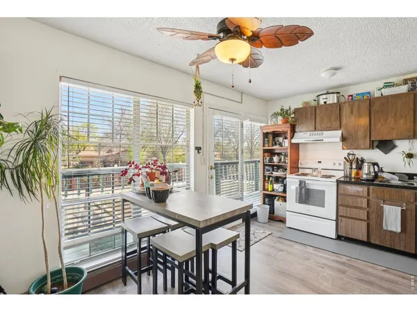 a kitchen with stainless steel appliances kitchen island granite countertop a table chairs sink and cabinets