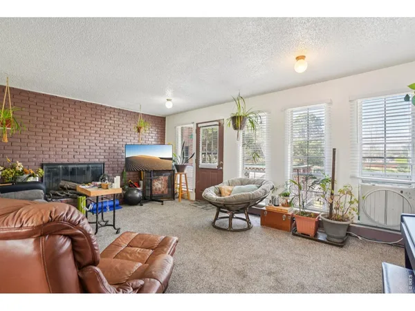a living room with furniture a fireplace and large windows