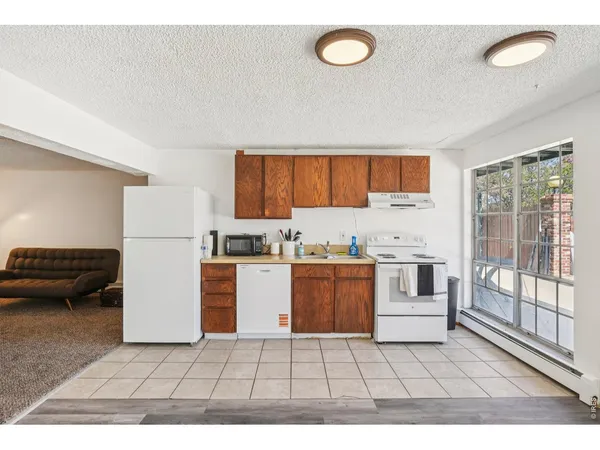 a kitchen with a refrigerator a stove top oven a sink and a window