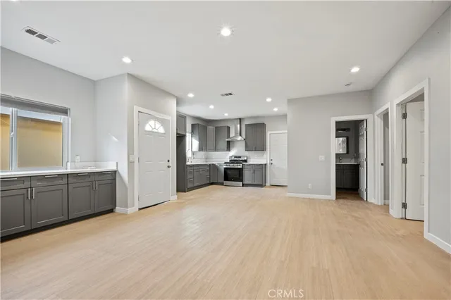 a large white kitchen with kitchen island a sink stainless steel appliances and cabinets