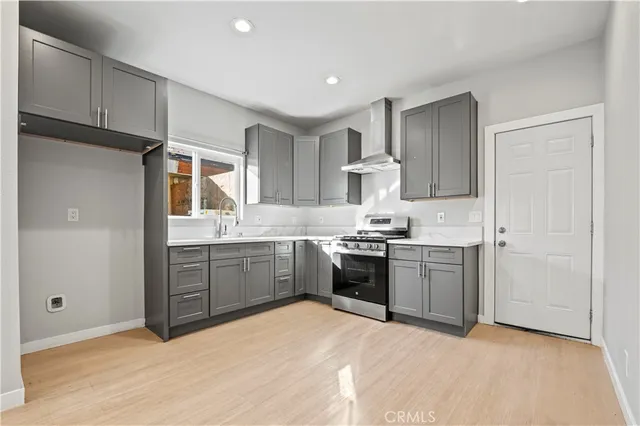 a kitchen with granite countertop a sink stove and refrigerator