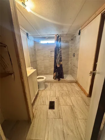 a view of a room with wooden floor and toilet