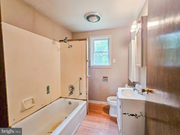 a bathroom with a tub a sink and a window