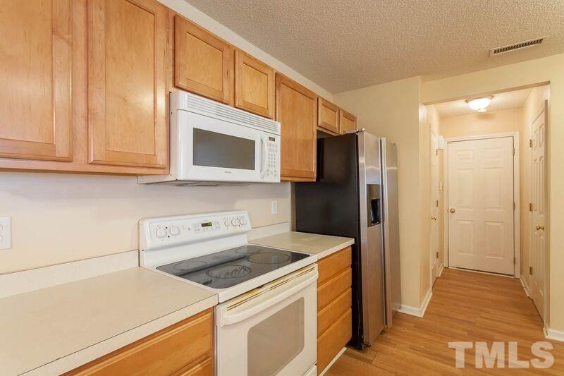 4904 Tommans Trail Raleigh, NC 27616 - Photo 8 of 20 a kitchen with a refrigerator stove and cabinets