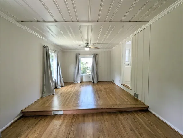 a view of empty room with wooden floor