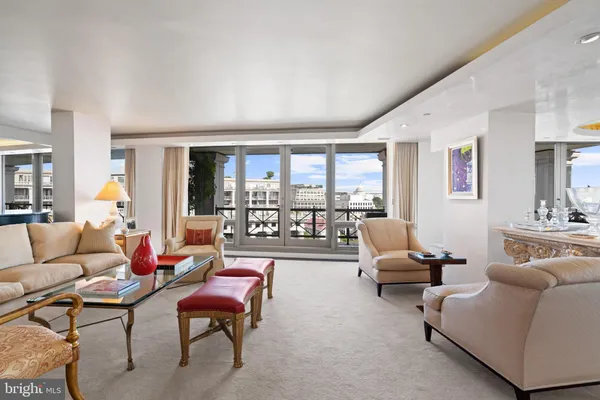 a living room with furniture and a large window with balcony view