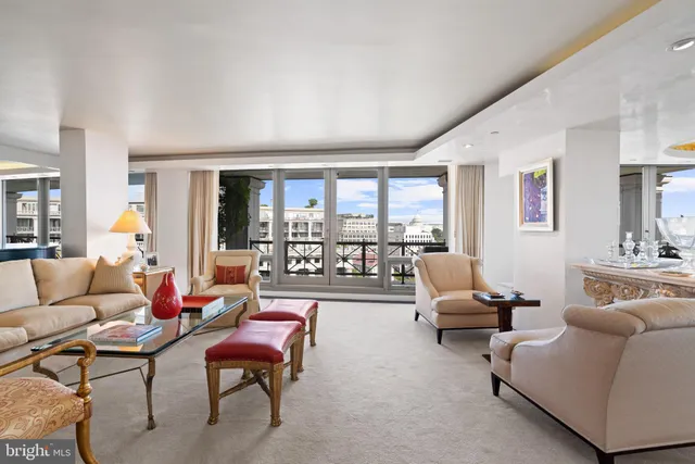 a living room with furniture and a large window with balcony view