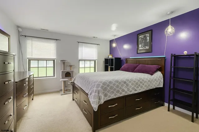 a spacious bedroom with a large bed and a dresser next to a window