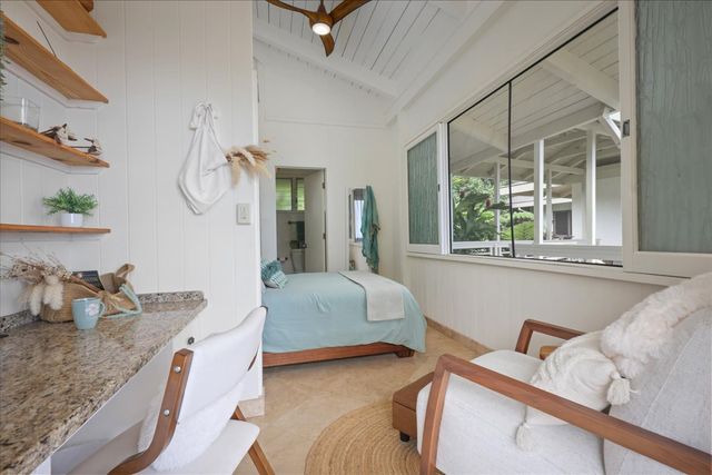 a bathroom with a granite countertop bathtub sink vanity mirror and toilet