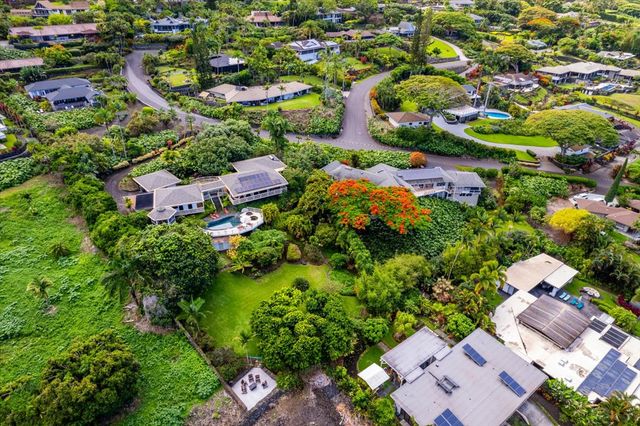 an aerial view of residential houses with outdoor space and trees all around
