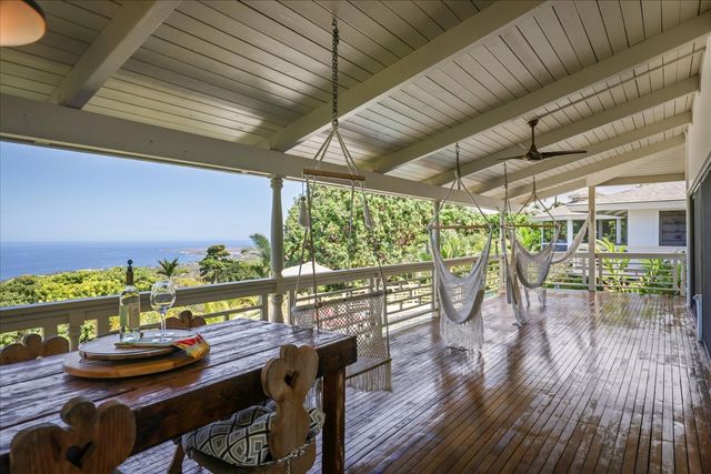 a living room with furniture a flat screen tv and a floor to ceiling window