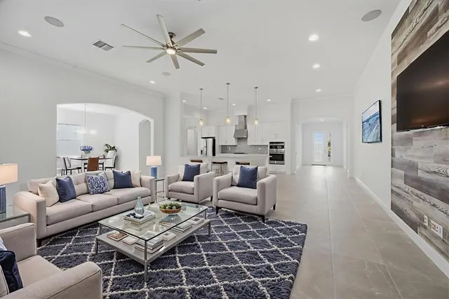 a living room with furniture kitchen view and a flat screen tv