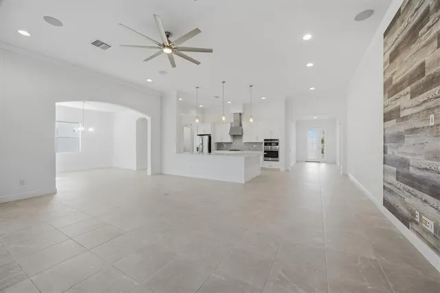 a view of an empty room and kitchen view