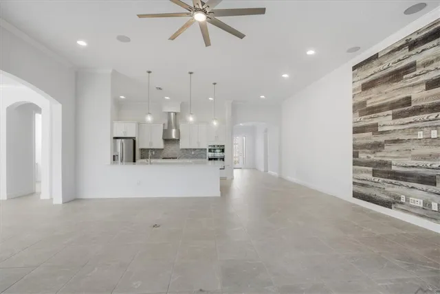 a view of an empty room and kitchen view