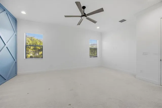 an empty room with a window and a fan