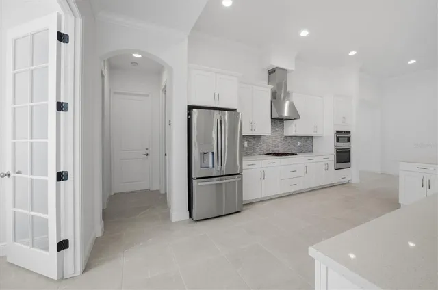 a kitchen with a refrigerator and white cabinets