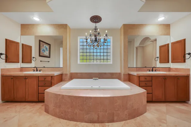 a spacious bathroom with a tub sink and mirror