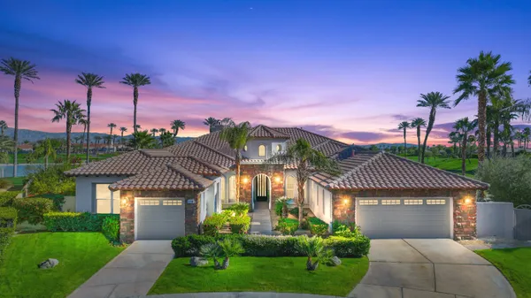 a front view of a house with a garden and a yard