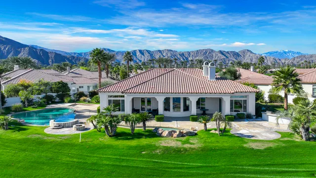 a front view of a house with garden and a swimming pool