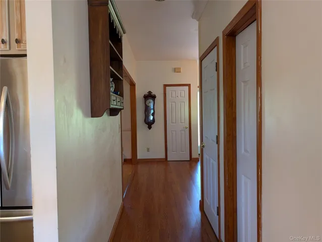 a view of a hallway with wooden floor and staircase