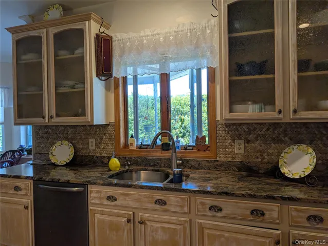 a kitchen with stainless steel appliances granite countertop a sink a stove and cabinets