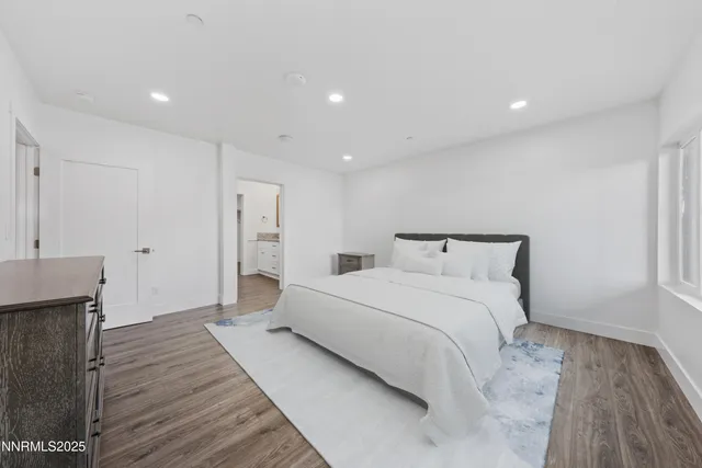 a spacious bedroom with a bed and a wooden floor