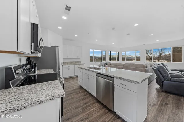 a kitchen with stainless steel appliances granite countertop a sink stove and refrigerator
