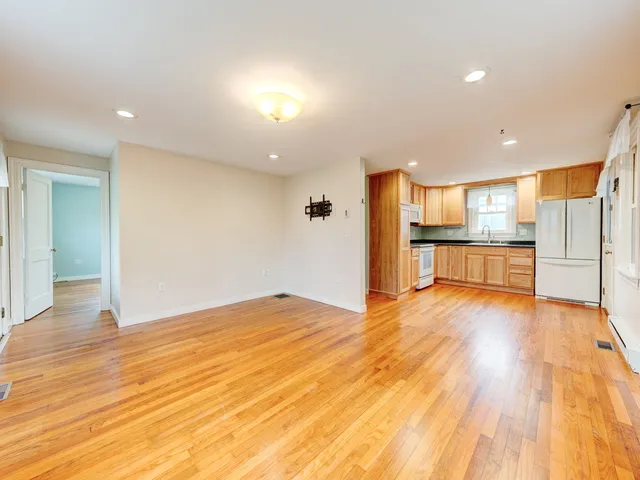 a kitchen with granite countertop a refrigerator and a stove top oven