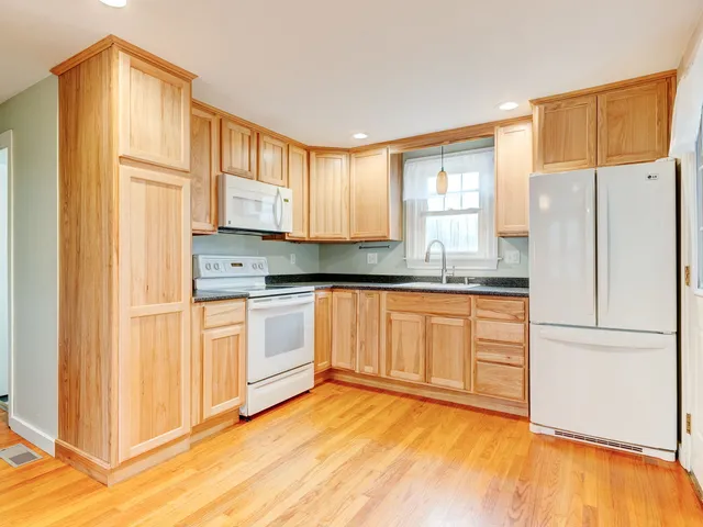 a view of a kitchen with wooden floor and electronic appliances