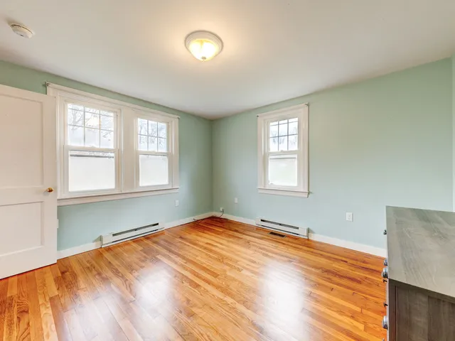 a view of room with window and wooden floor