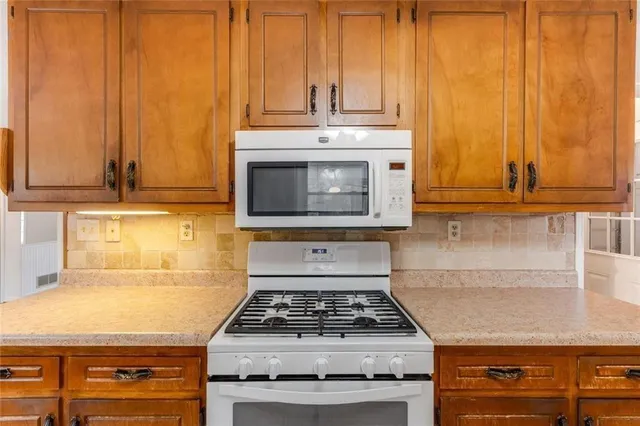 a stove top oven sitting inside of a kitchen