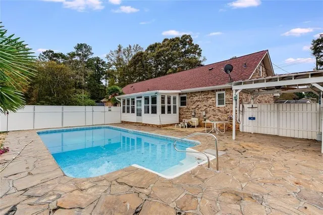a view of a house with swimming pool and sitting area