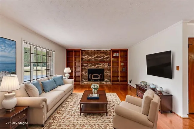 a living room with furniture a flat screen tv and a fireplace