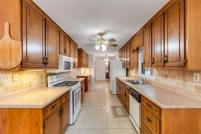 a kitchen with stainless steel appliances granite countertop a sink a stove and a wooden cabinets