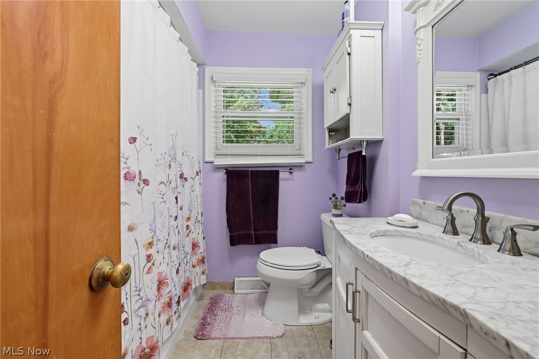 1499 Morris Road Kent, OH 44240 - Photo 6 of 41 Bathroom featuring a vanity with a white stone countertop and undermount sink, dual-handle faucet, white cabinetry, and a framed mirror