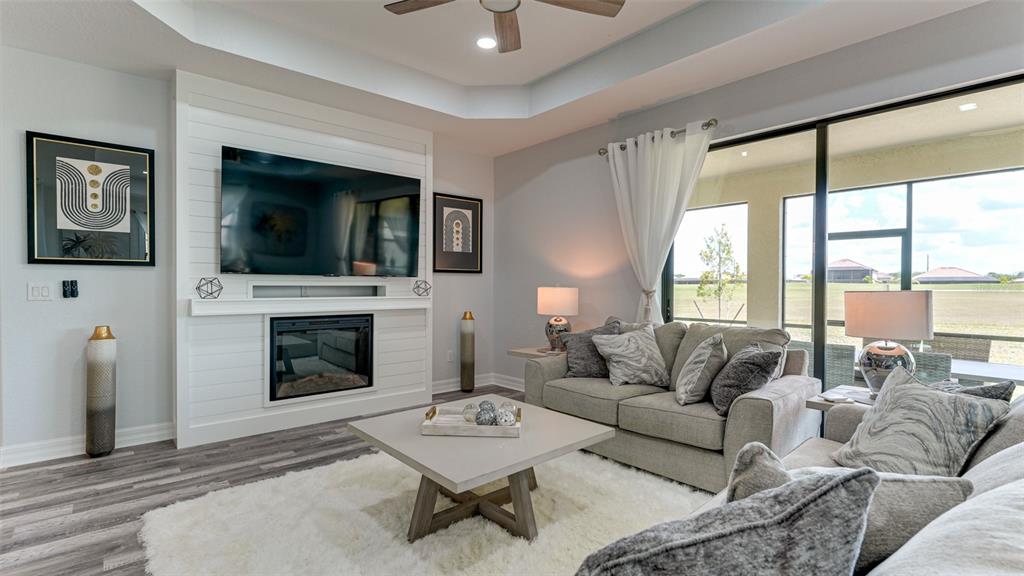 5725 Cheech Glen Lakewood Ranch, FL 34211 - Photo 23 of 63 a living room with furniture a flat screen tv and a fireplace