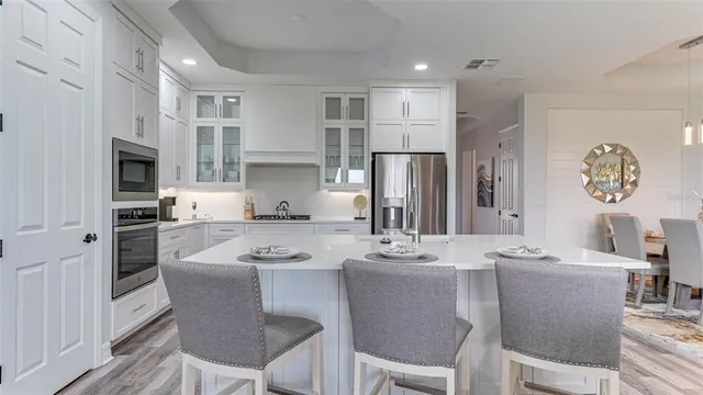 a kitchen with white cabinets and refrigerator