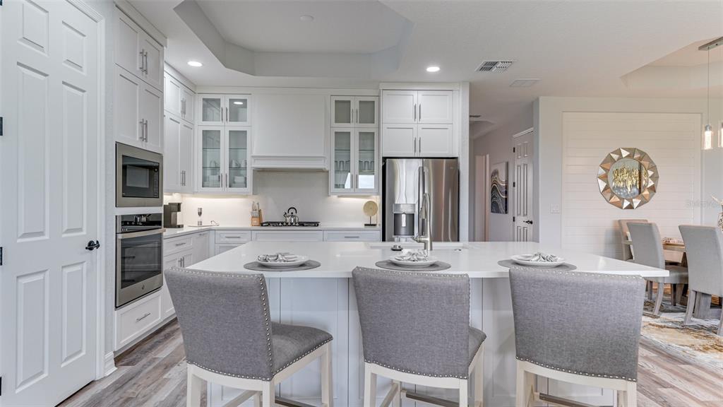 5725 Cheech Glen Lakewood Ranch, FL 34211 - Photo 3 of 63 a kitchen with stainless steel appliances granite countertop a dining table chairs refrigerator and sink