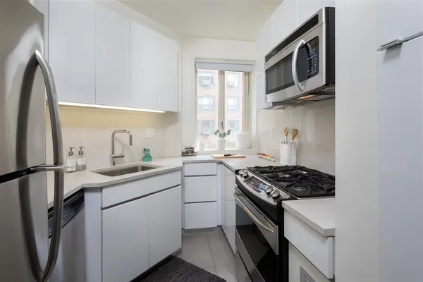 a kitchen with stainless steel appliances a sink stove and refrigerator