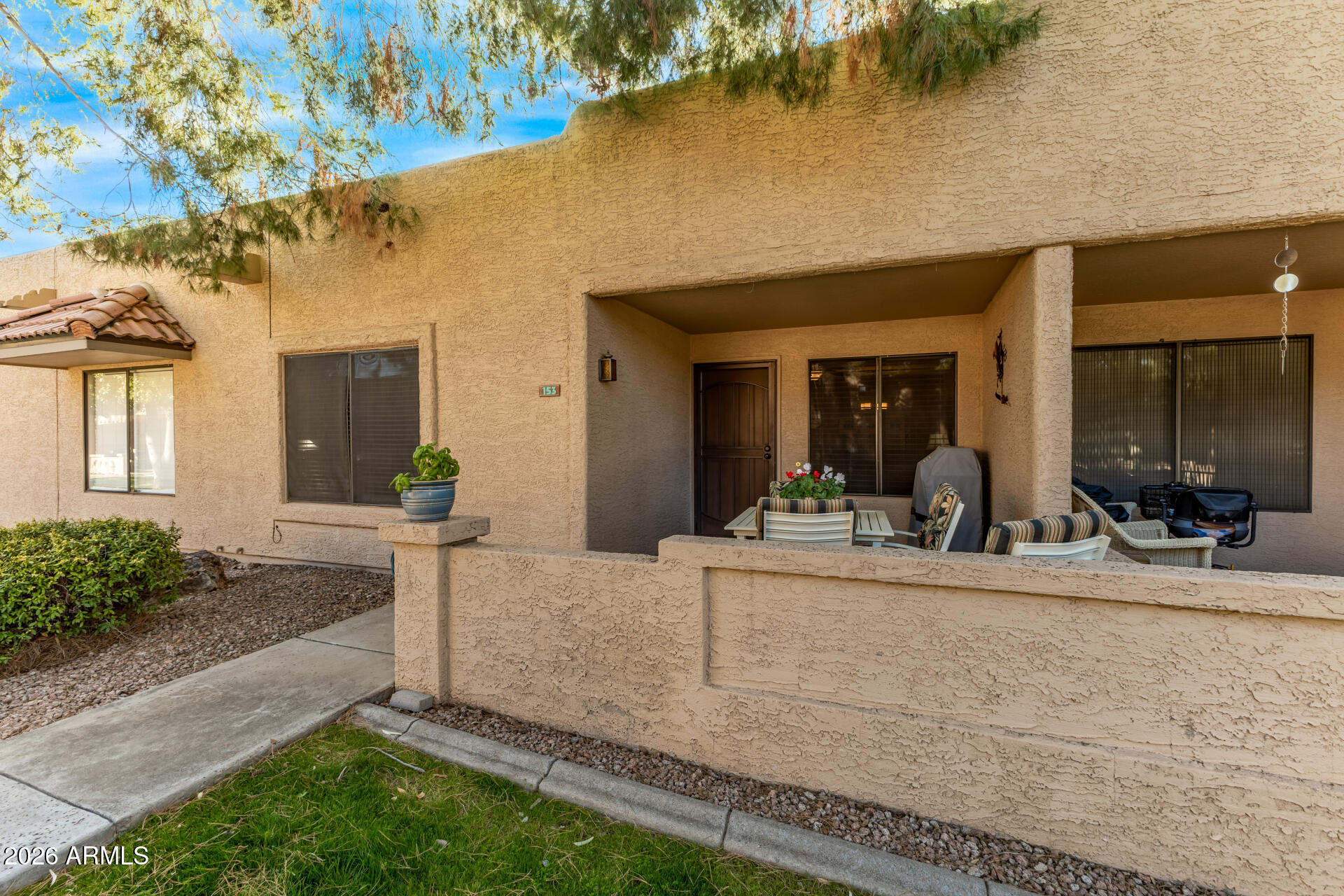 14300 West Bell Road, Unit 153 Surprise, AZ 85374 - Photo 3 of 19 a view of a house with potted plants and a table and chairs