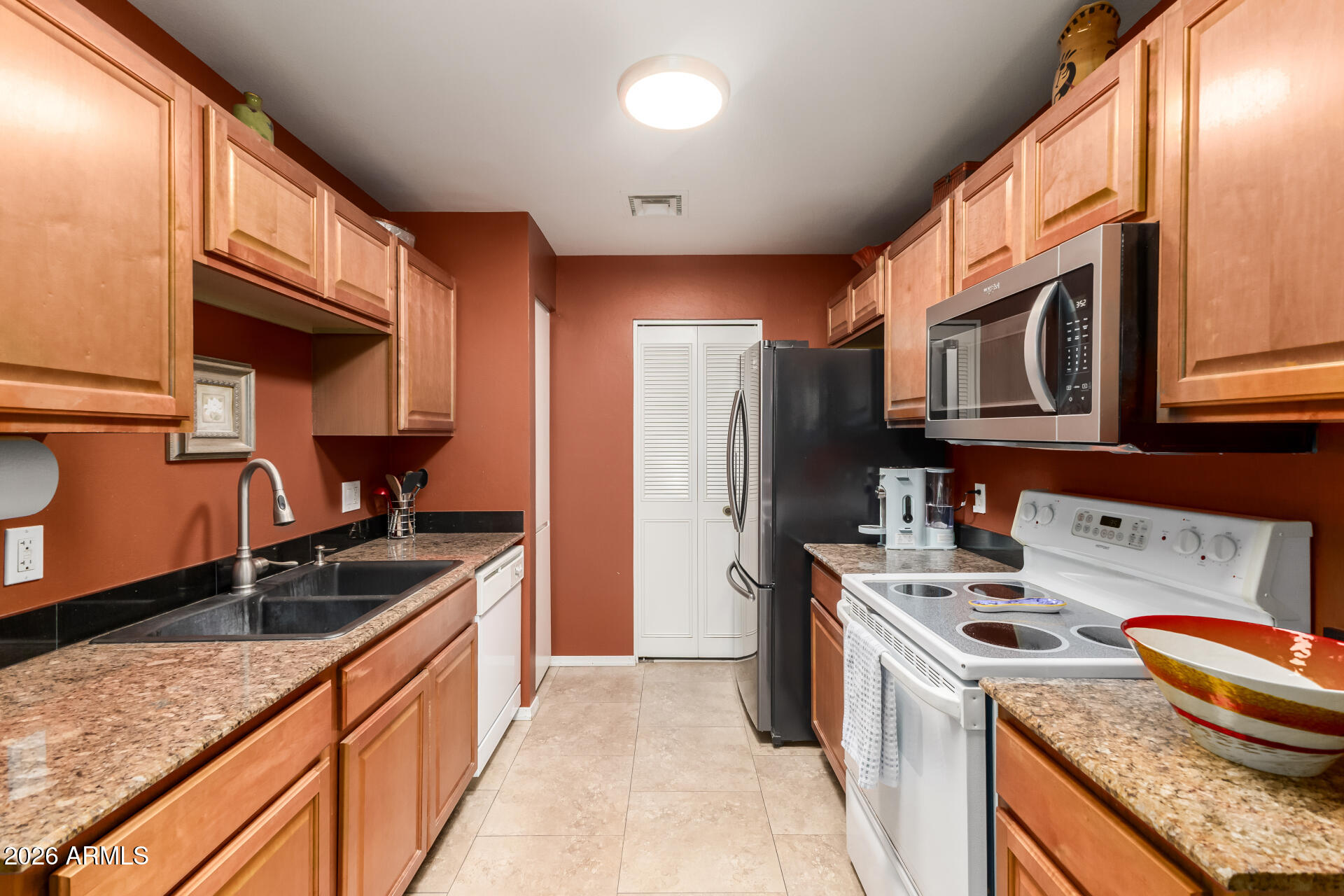 14300 West Bell Road, Unit 153 Surprise, AZ 85374 - Photo 7 of 19 a kitchen with stainless steel appliances granite countertop a sink stove and refrigerator