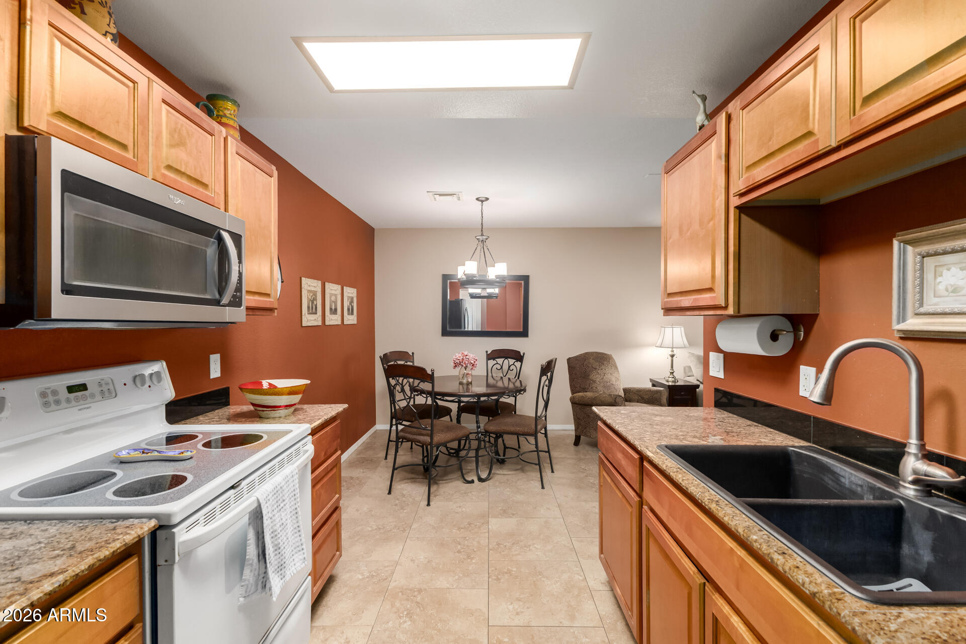 14300 West Bell Road, Unit 153 Surprise, AZ 85374 - Photo 9 of 19 a kitchen with a stove a sink and a microwave