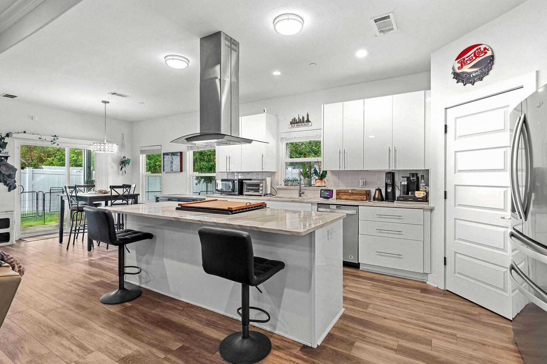 a kitchen with stainless steel appliances kitchen island granite countertop a stove a sink and a refrigerator