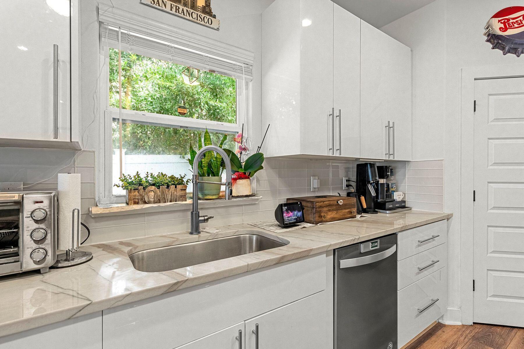 736 Comanche Drive Fort Walton Beach, FL 32547 - Photo 16 of 49 a kitchen with stainless steel appliances a sink a stove and white cabinets next to a window