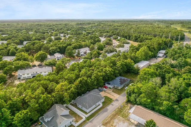 an aerial view of residential houses with outdoor space and trees
