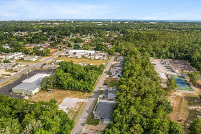 an aerial view of residential houses with outdoor space and trees
