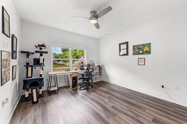 a view of a workspace with furniture and a window