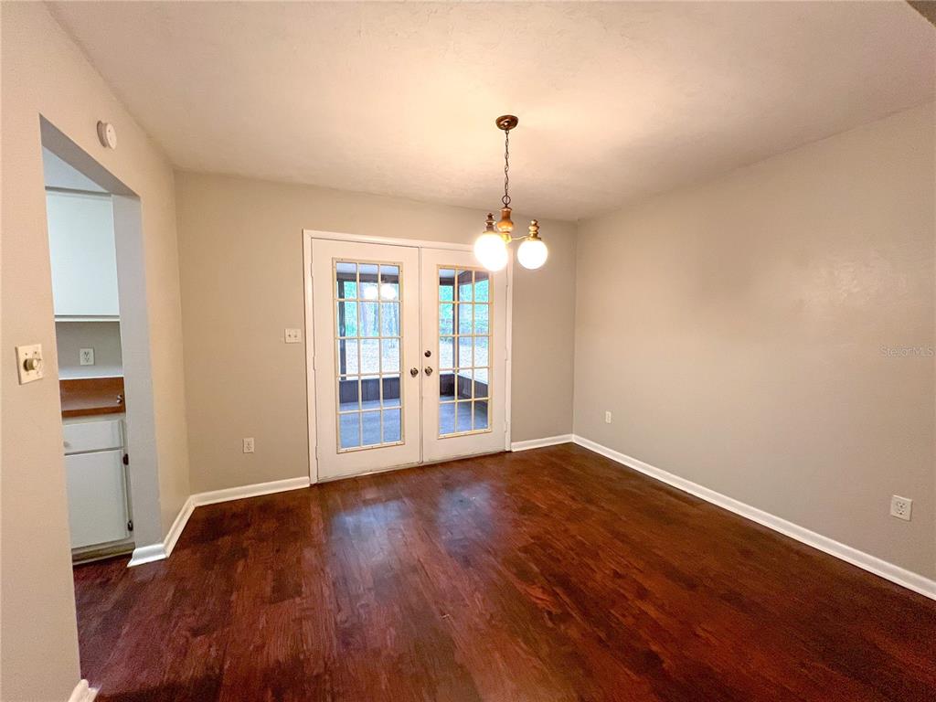 720 Southwest 77th Terrace Gainesville, FL 32607 - Photo 4 of 17 a view of a room with wooden floor and a chandelier